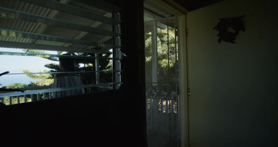 Woman walks outside onto balcony to sit and watch view