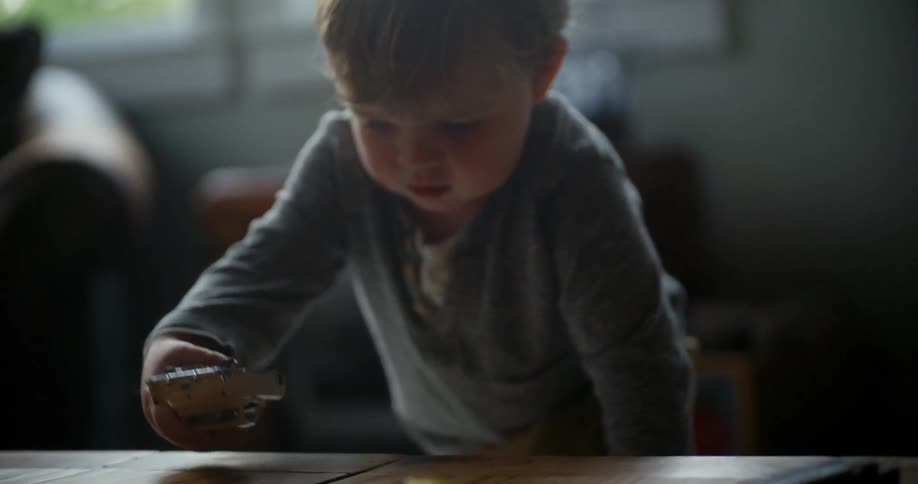 A young child plays with his toys