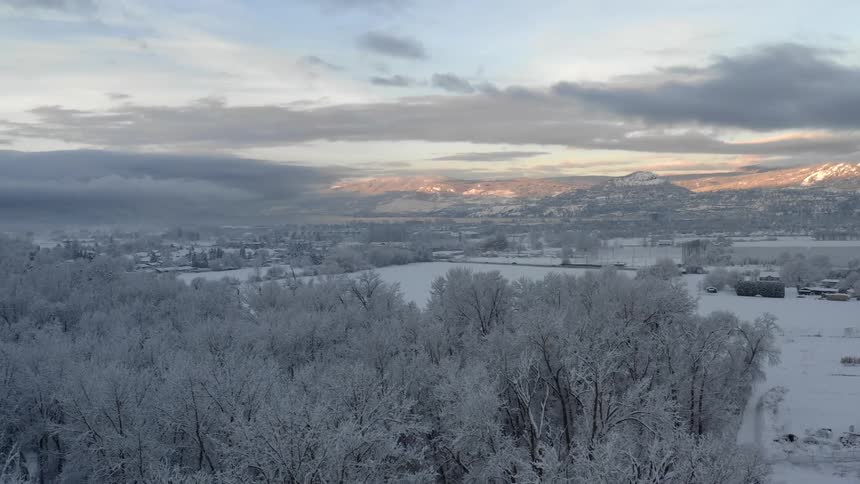 Landscape view of a snowy field with mountains in the background