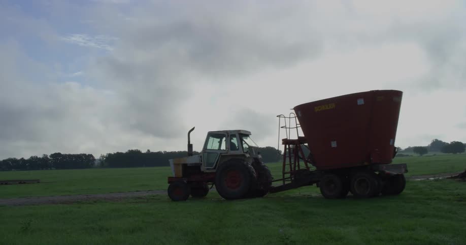 A tractor towing farming equipment across a field