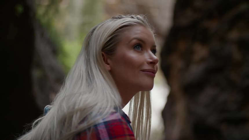 A young woman looks around outside
