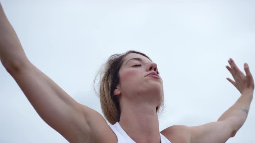 A woman outside stretching with the sky above