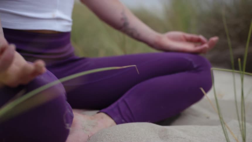 A person sitting on sand meditating
