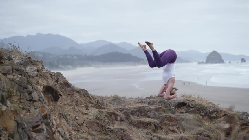 A woman does yoga on the rocks