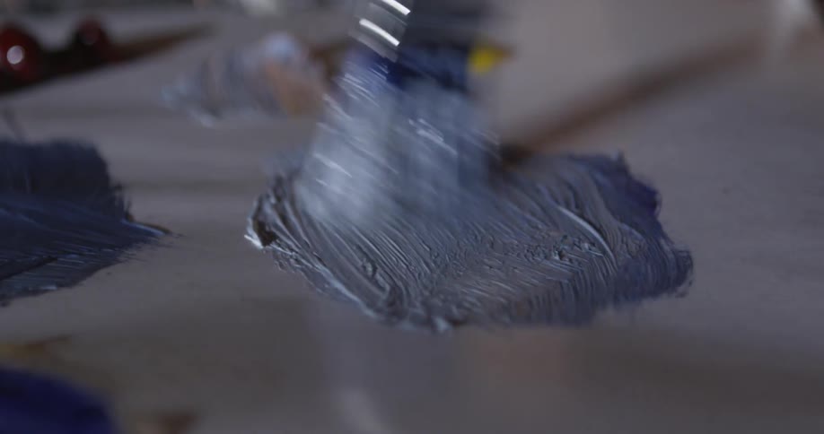 Someone mixing paint on a piece of paper