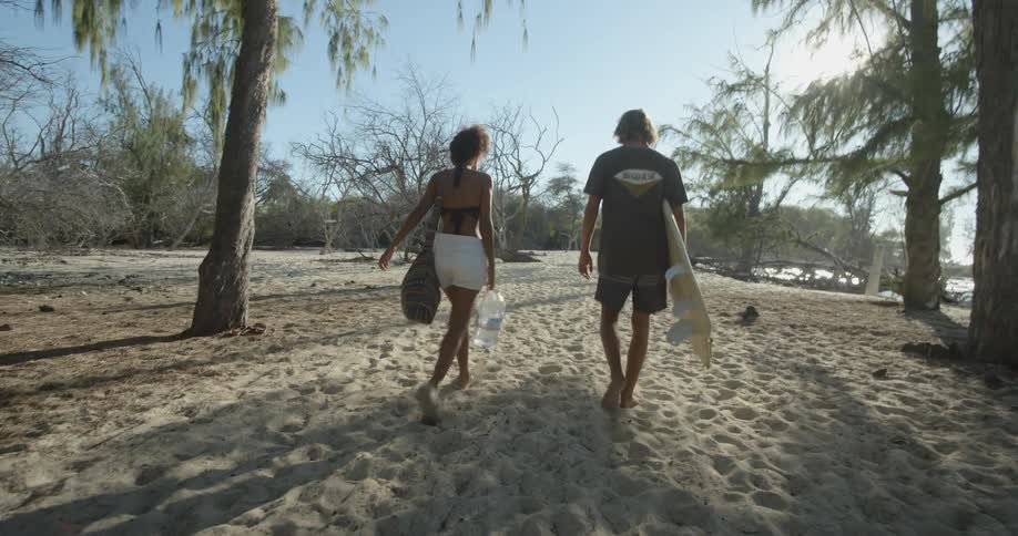 A woman and man are walking on the beach