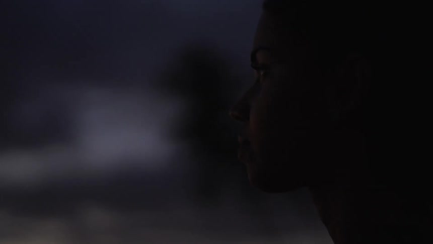 A woman stands outside at night