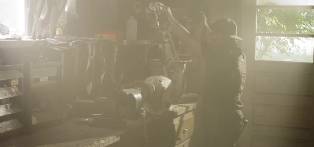 A man adjusting a machine on a wooden counter