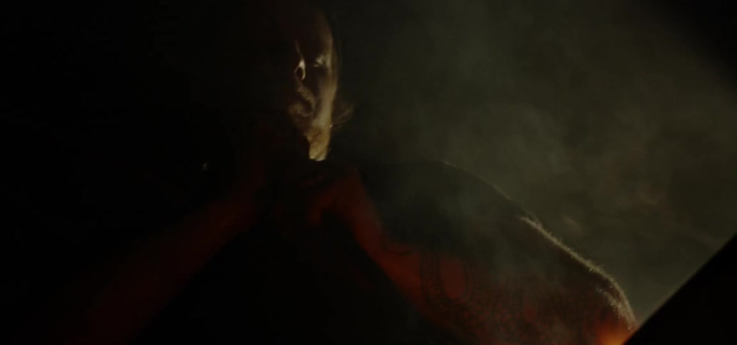A person pushing a stick into a fire