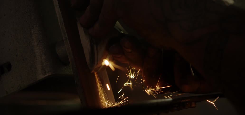 A person using a machine to grind a piece of metal