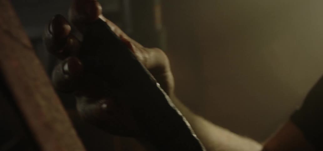 A man holds a piece of metal in a workshop