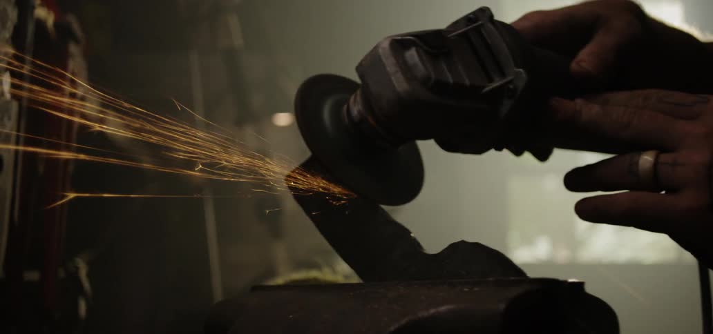 A person using an electric grinder on a piece of metal