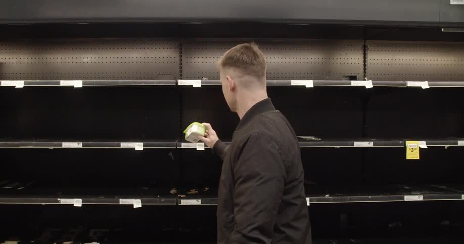 Man picks last item of empty grocery store shelves