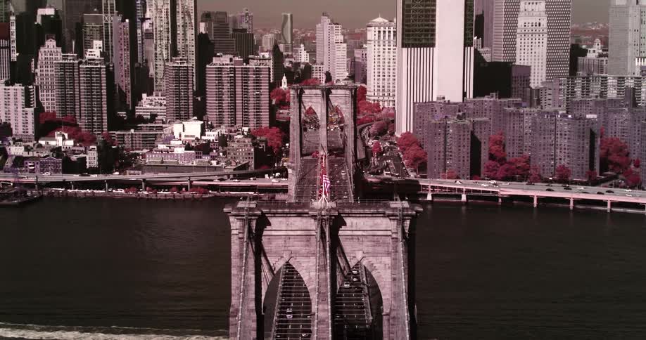 An aerial view of a large city bridge with skyscrapers in the distance