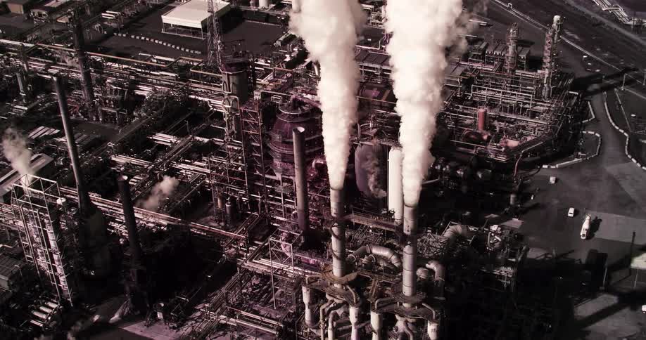Smoke streams straight up from refinery smokestacks
