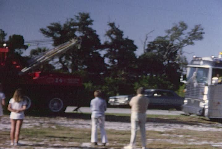 Bystanders watch a tow truck and firetruck