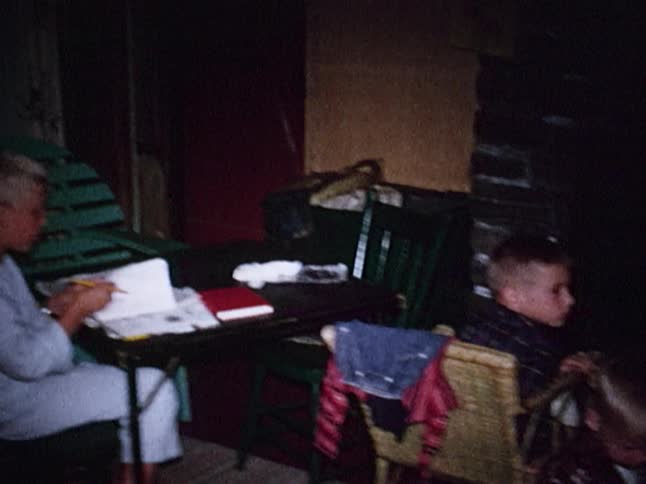 Boys sit in front of a fireplace reading and watching the fire