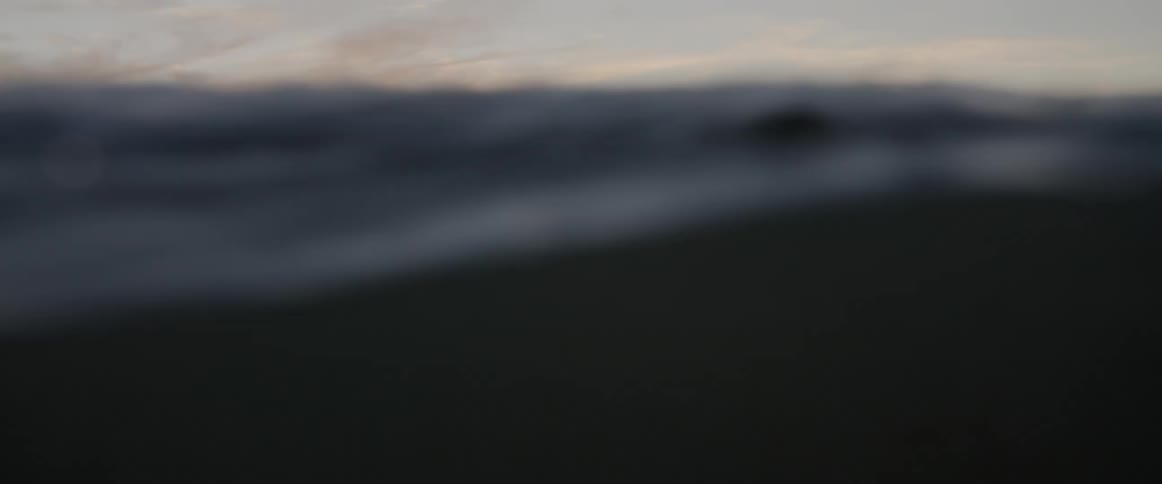 Man swimming above a surfboard in the middle of the ocean