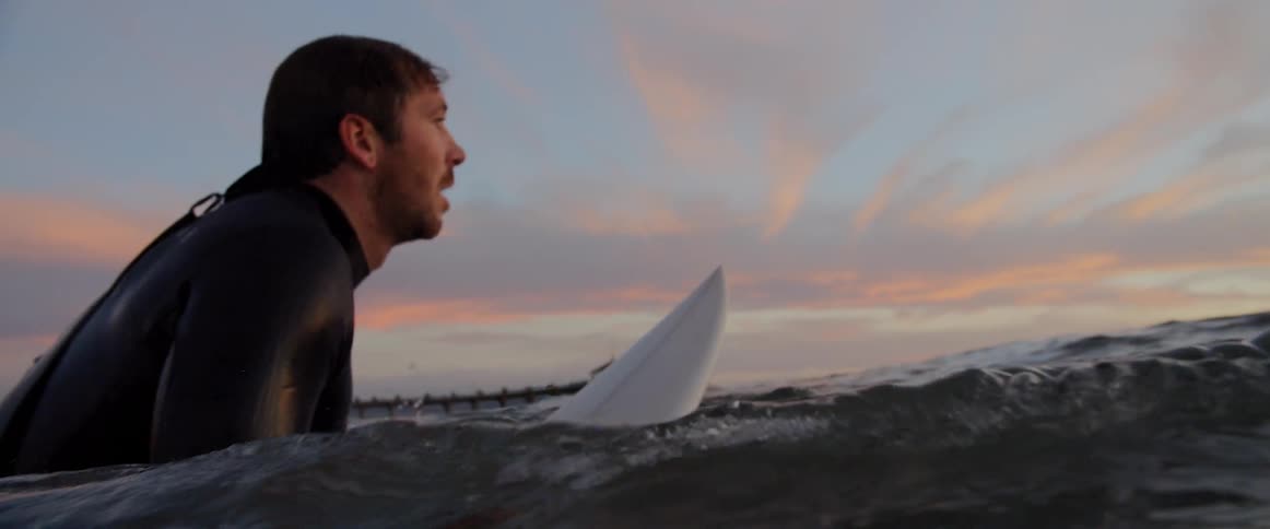 A man gets on his surf board