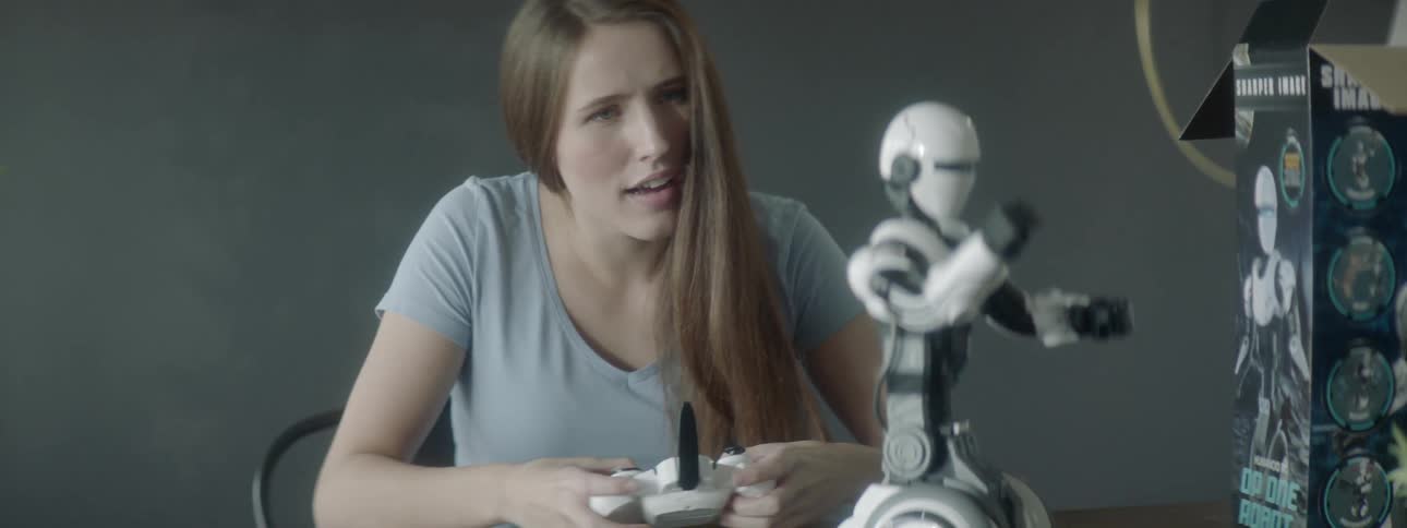 A young woman is controlling a robot