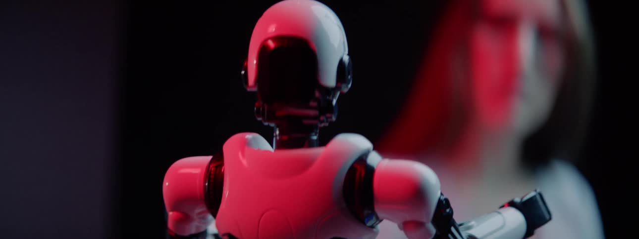 Woman observes small robot maneuver