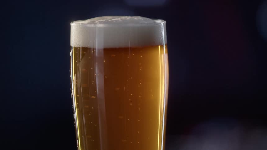 Bubbles rise to the top of a foam topped glass of beer