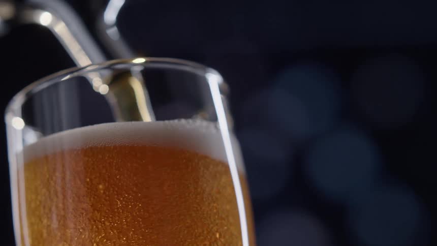 Close up of beer being poured in a glass from the tap