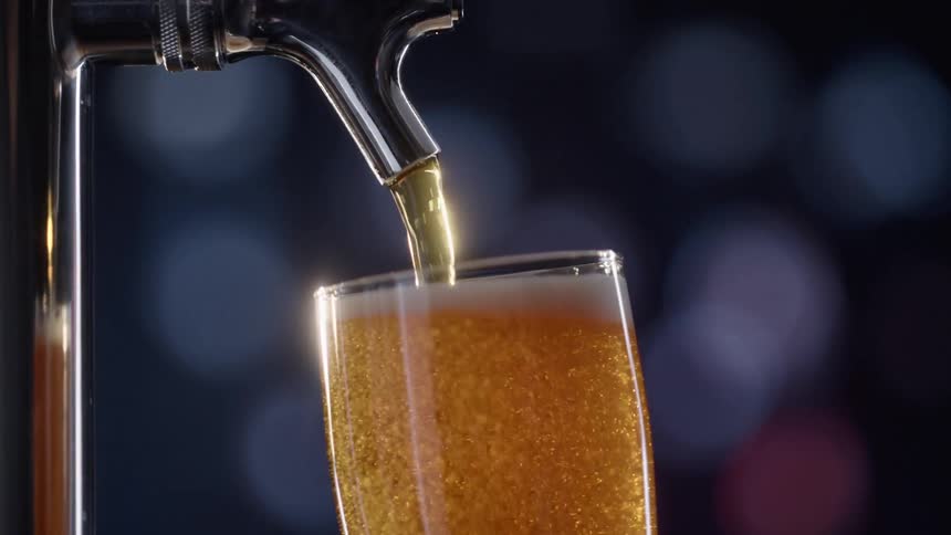 Beer is being poured from a tap in to a glass
