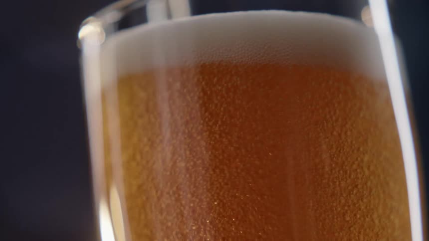 Beer being poured into a tall glass