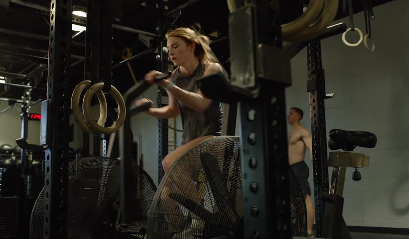 A woman doing exercises on an exercise bike in a gym