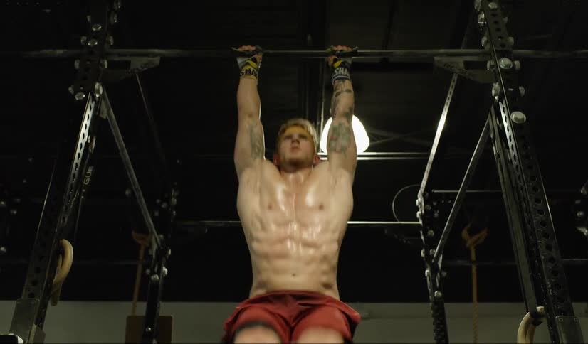 A man swings on parallel bars
