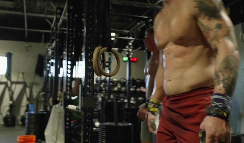 A blonde man with muscles swinging on a bar