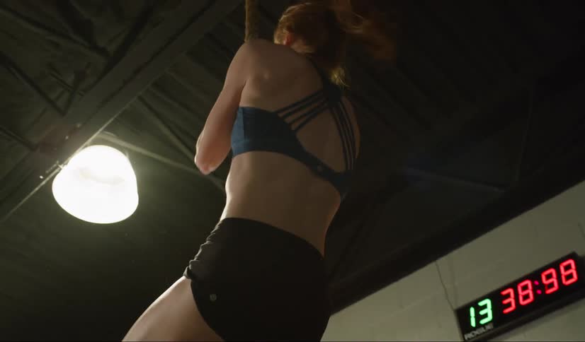 A woman climbs a rope in a fitness center