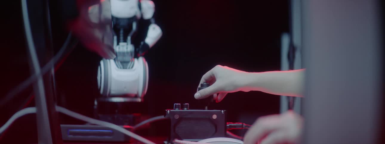 A woman working on computer equipment to control a robot