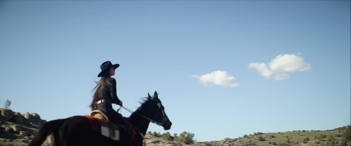 Slow motion view of woman horseback riding in the desert