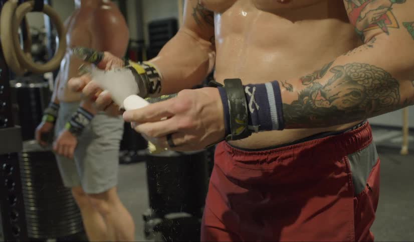 Several shirtless men are working out in a gym