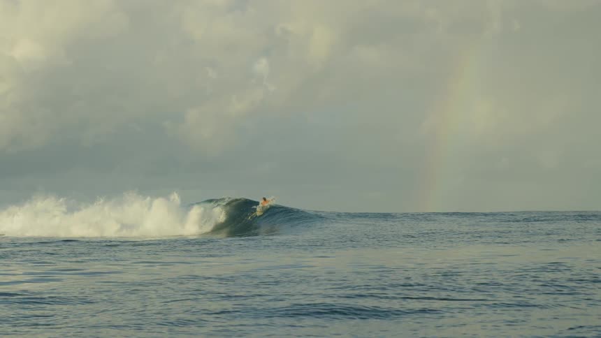 Two men surfing a wave at the ocean