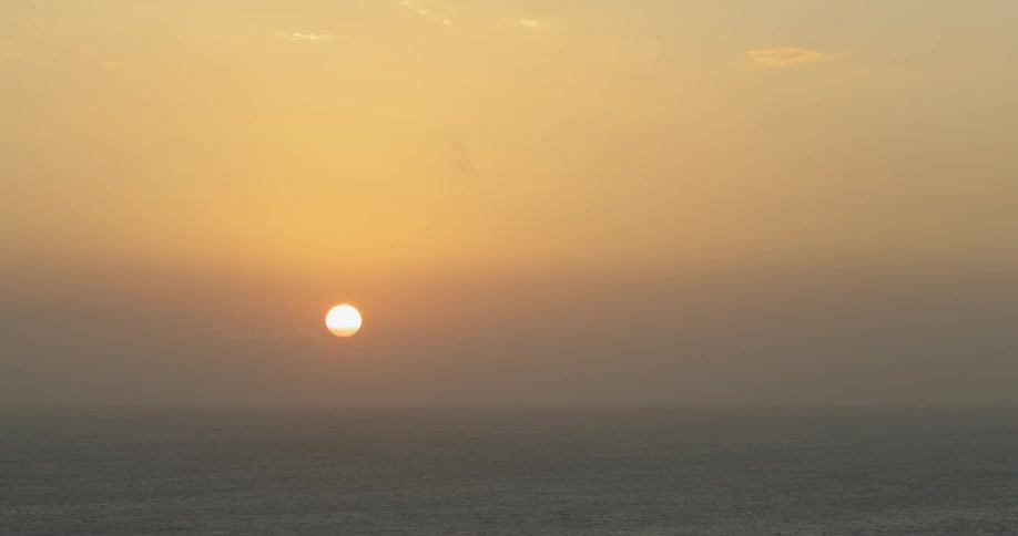 Sunset over the ocean cast light over clouds