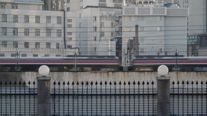 A train traveling along a bridge through a city