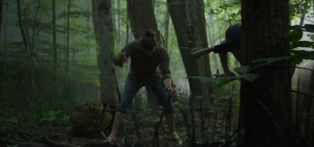 Men chop branches with axes