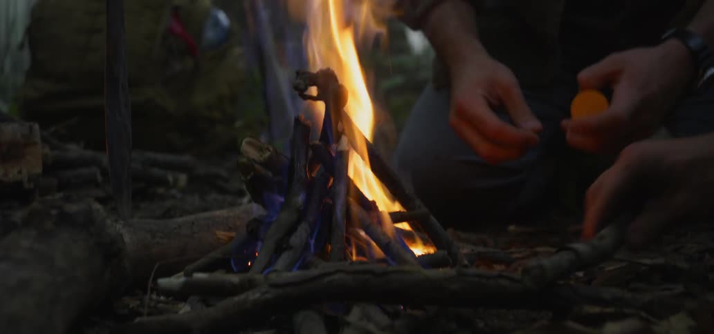 Two white man lighting a fire on the woods