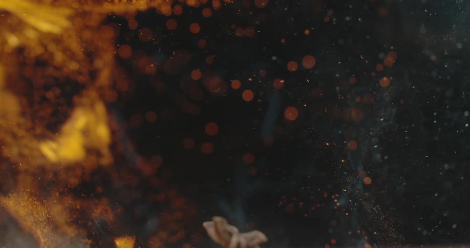 Smoke and embers rise up after flame quickly roast herbs and spices