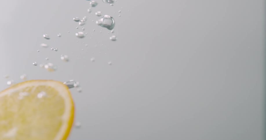 A lemon slice descending through water