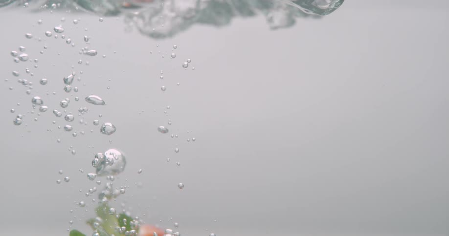 Strawberries falling down the water