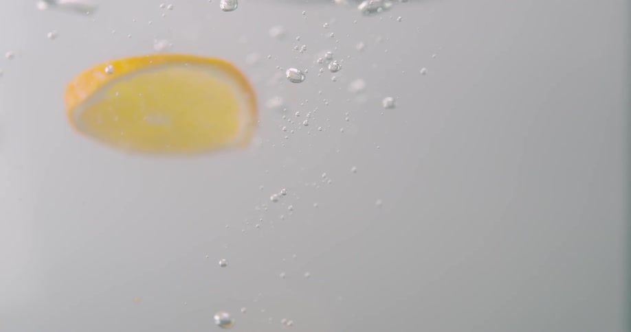 Orange slices are falling through water