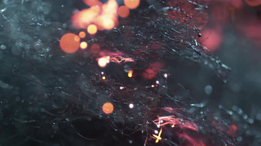 Hairlike material slowly burn as flames flicker along the tips of the fibers