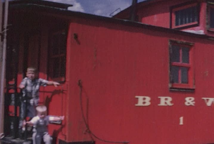 Little boys on the back of an old red train