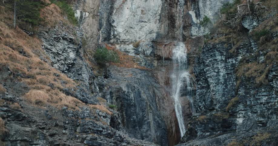 Waterfall on steep cliff in the mountains