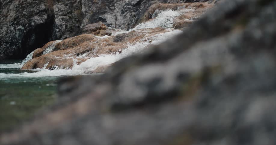 Close up view of water flowing down rocks into a stream in canyon
