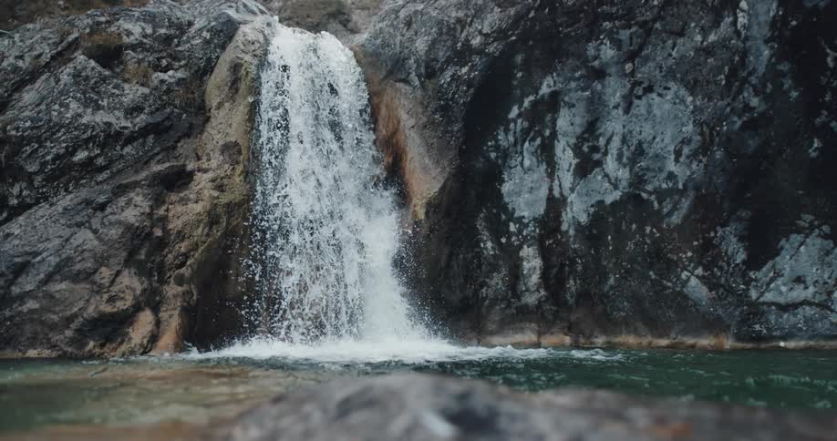 A waterfall crashes down the side of a cliff